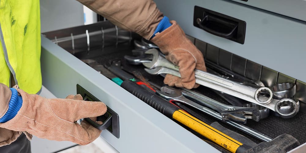 Technician getting tools using bale style pull handle toolbox.